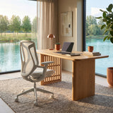 White BIRCH ergonomic chair beside a wooden desk in a sunlit lakeside home office