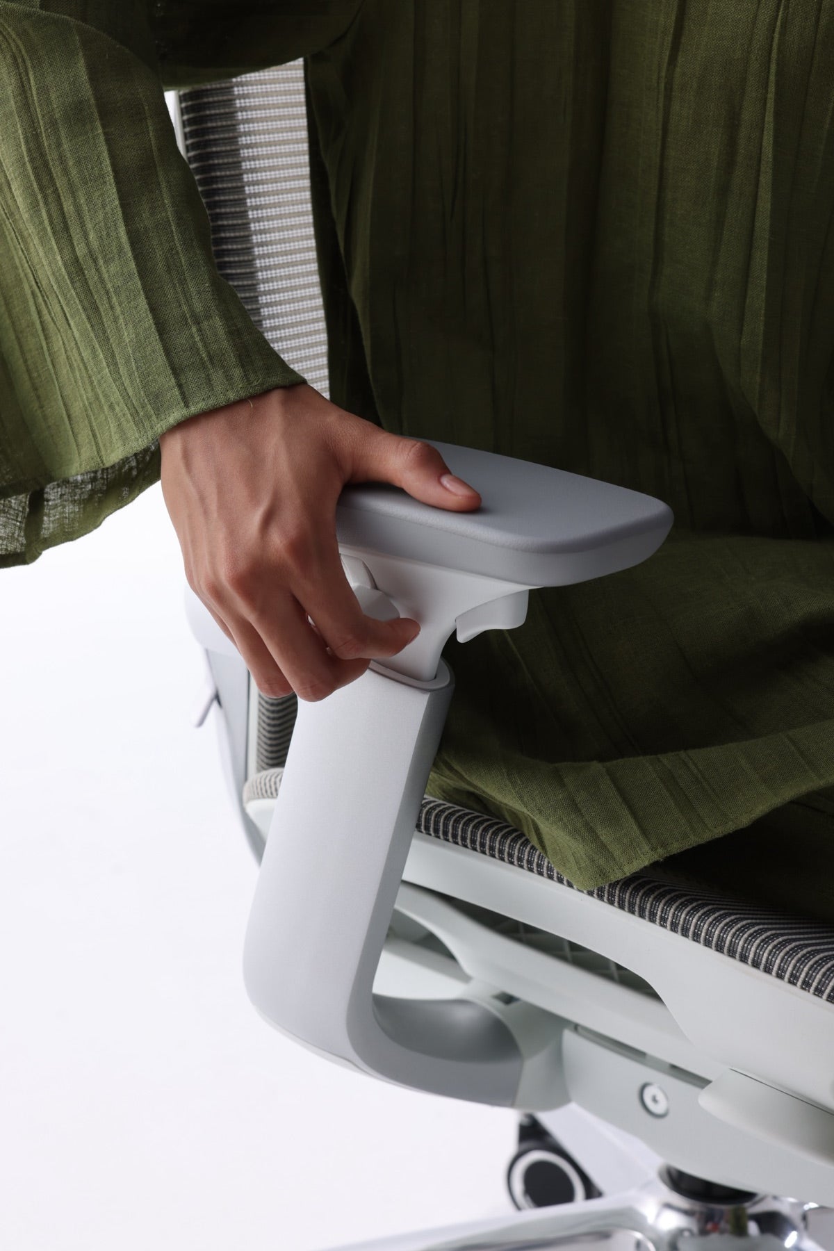 A hand using the control positioned beneath the BIRCH armrest